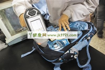 实验人员正在测试书包的重金属含量。两款书包测出重金属铅。
